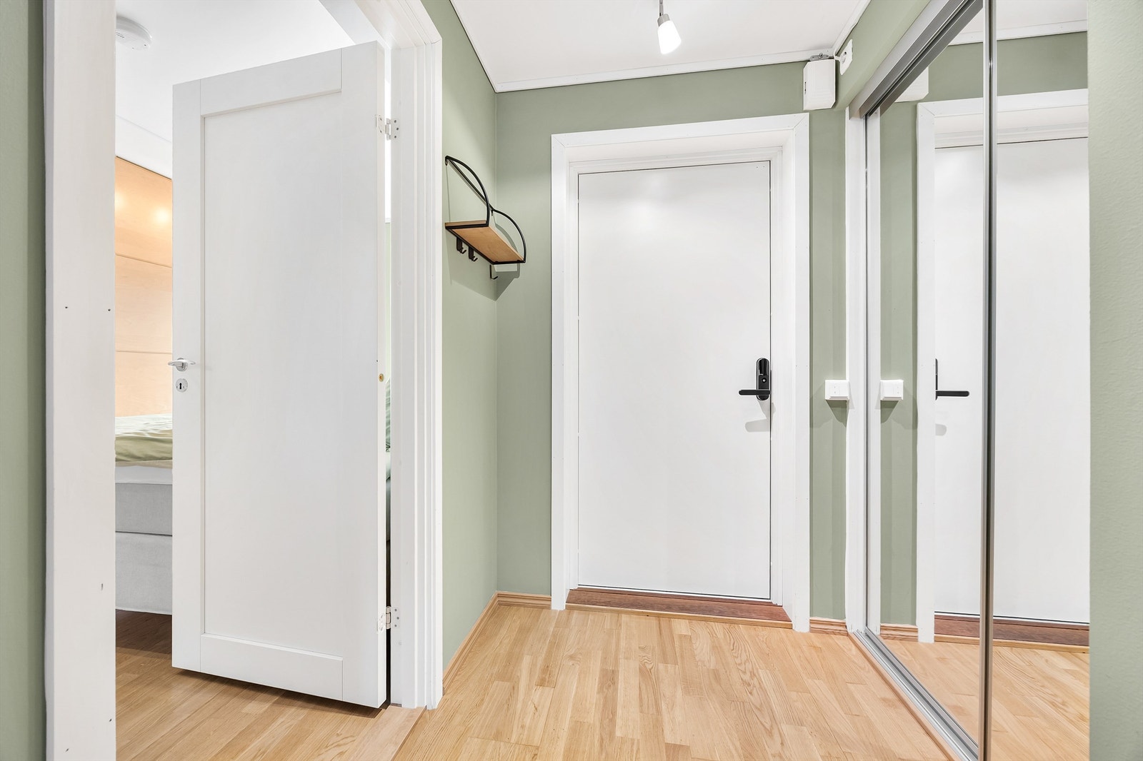 Lys entré med plassbygd garderobeskap med skyvedører av speil. Galleribilde