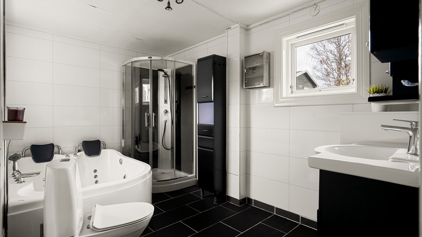 Stort bad med dusj, badekar, frittstående toalett og innredning for oppbevaring Galleribilde