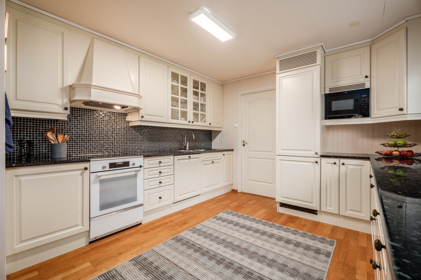 Et lyst kjøkken med rikelig skap- og benkeplass. Galleribilde