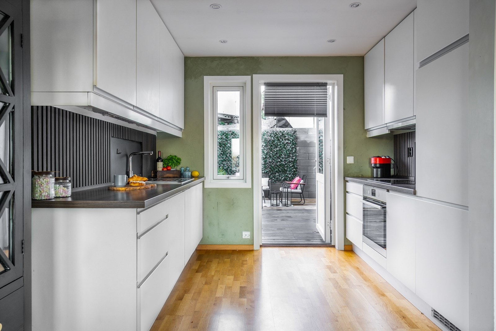 Kjøkkenet har innredning med glatte fronter. Benkeplaten er av laminat og det er spiler mellom over- og underskap. Det følger med kjøl/fryseskap, oppvaskmaskin, platetopp, stekeovn og komfyrvakt. Galleribilde