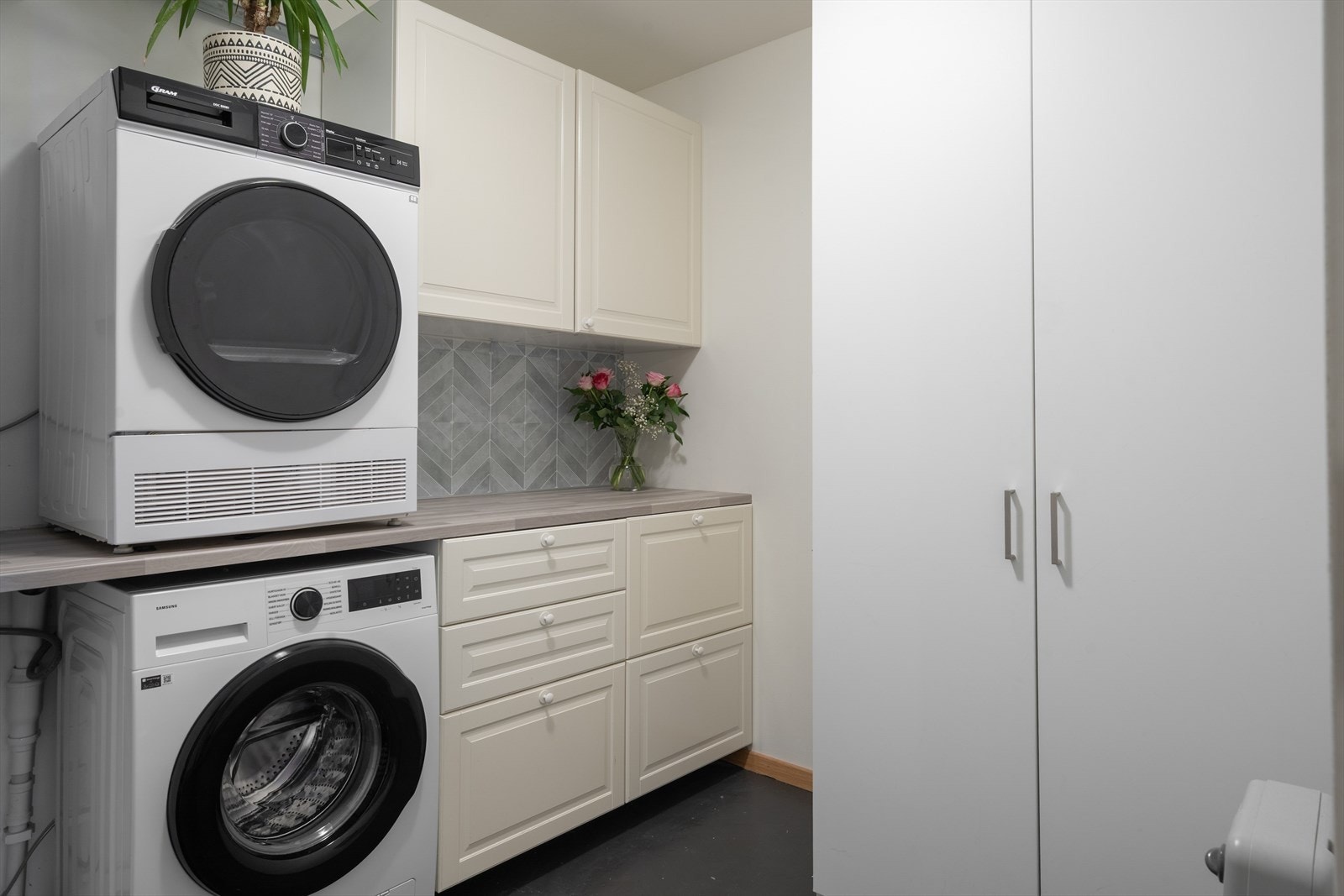 Praktisk vaskerom med plass til vaskemaskin og tørketrommel samt mye plass til oppbevaring. Galleribilde