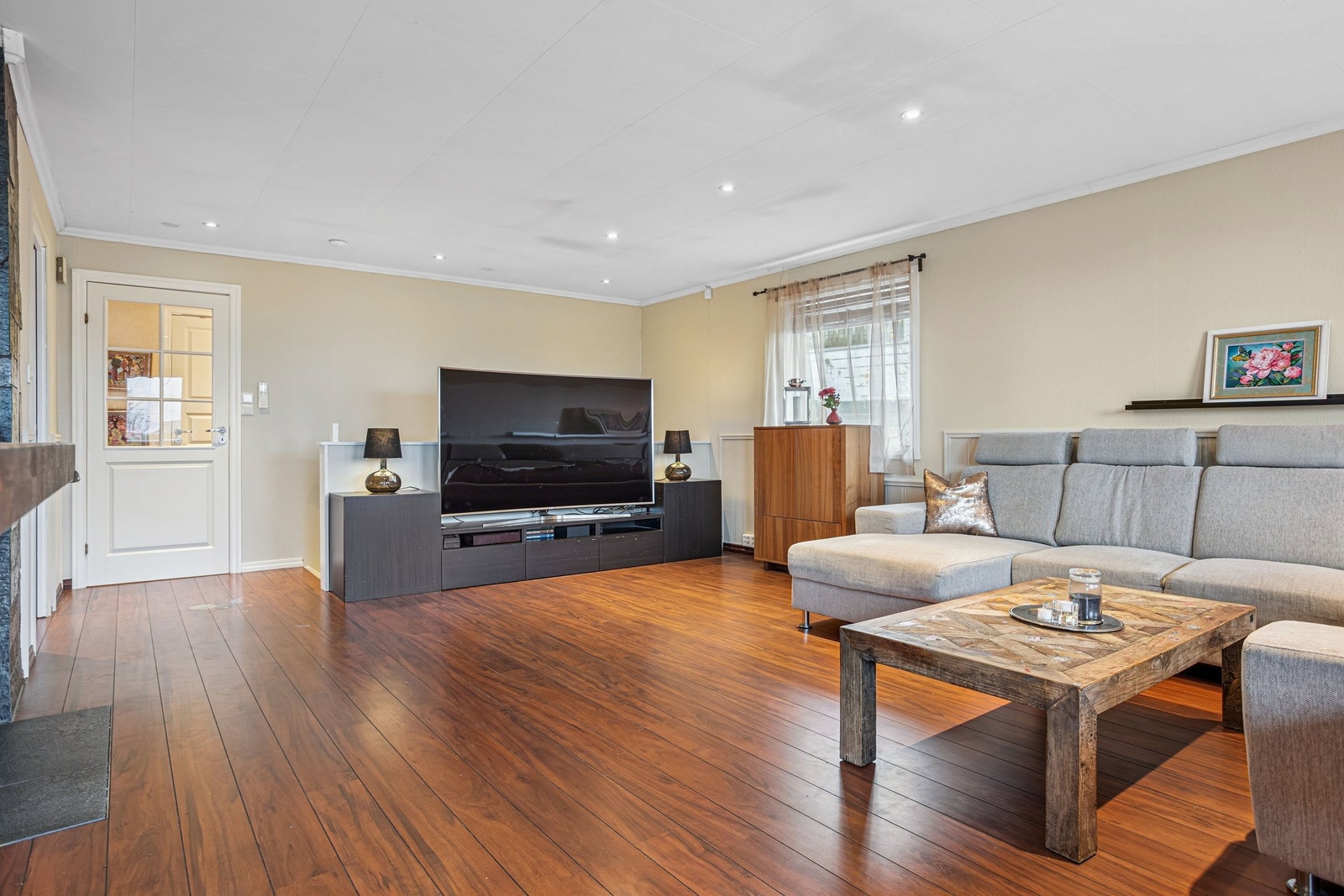 Stue er roomslig med flere vinuer for å slippe in dagslys. Galleribilde