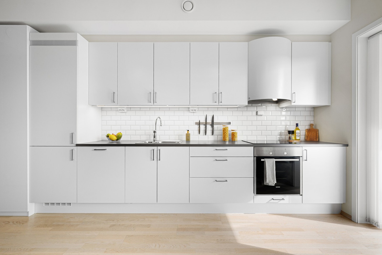 Kjøkkeninnredning med plane fronter, folierte skrog og laminert benkeplate. Galleribilde