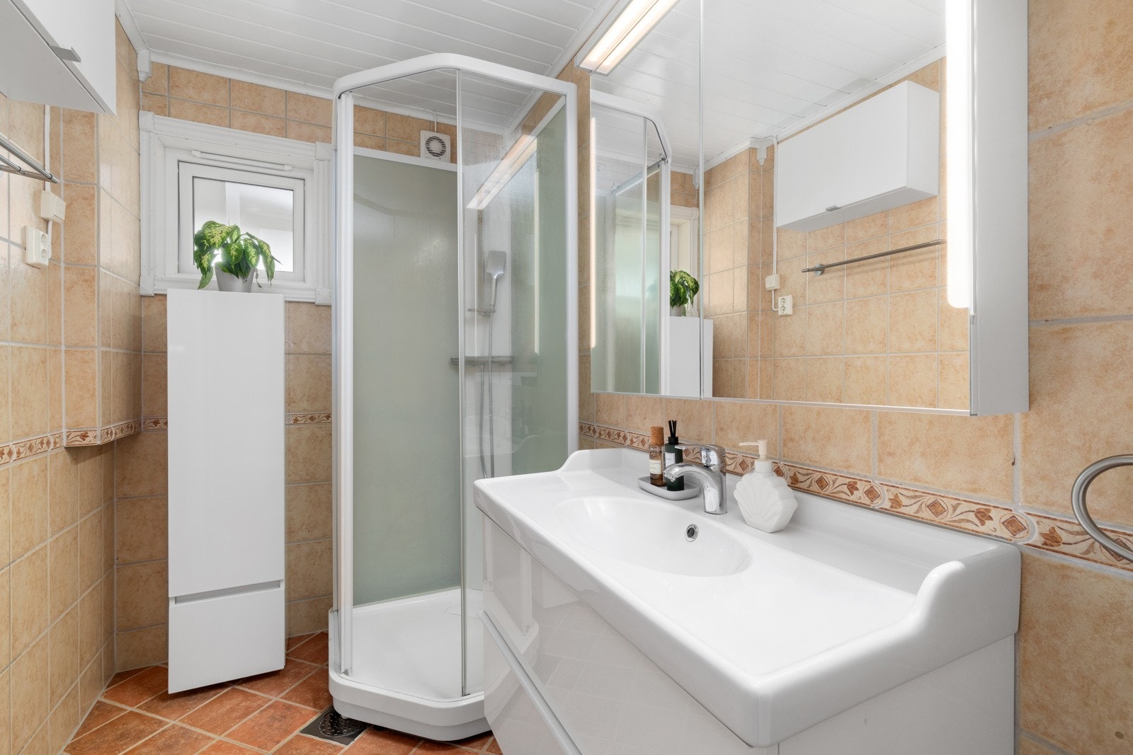 Rommet har elektriske varmekabler. Bad med sanitærutstyr bestående av klosett, helstøpt servant og dusjkabinett. Opplegg for vaskemaskin. Galleribilde