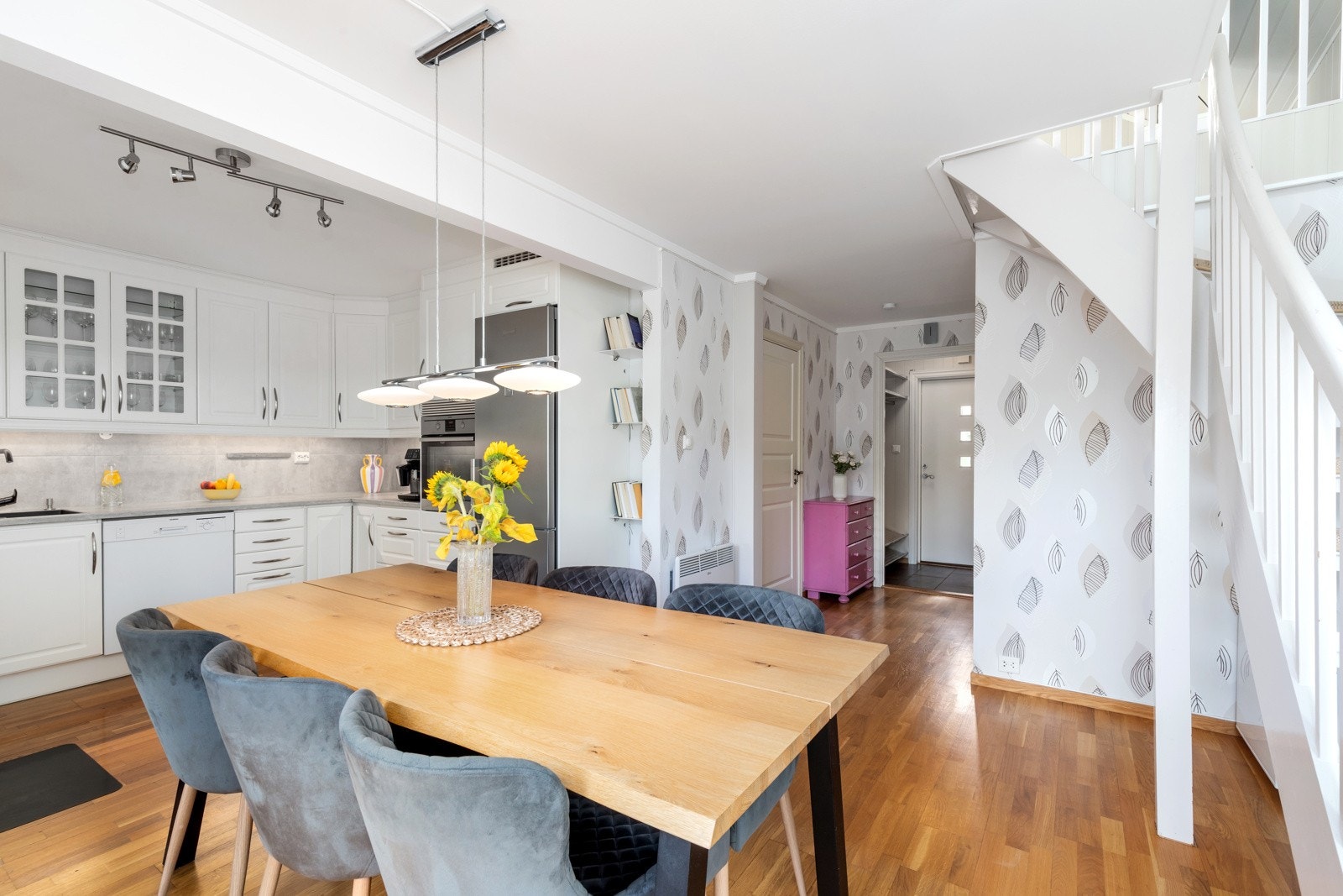 Spisestuen med åpenløsning mot kjøkkenet og vedovn. Galleribilde