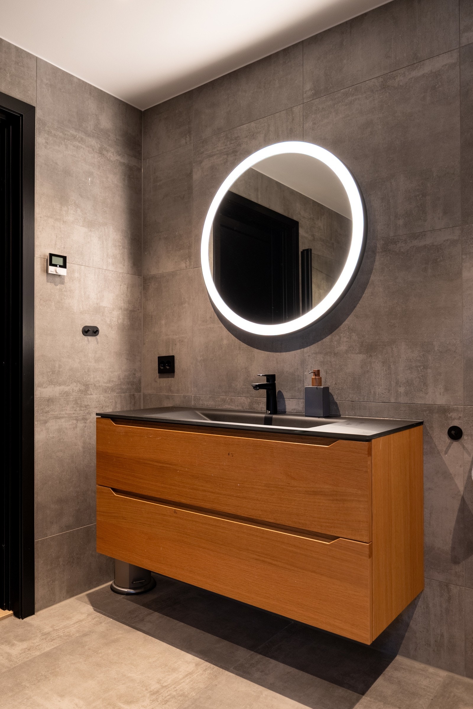 Familiebadet har speil over servant med belysning i speilet, samt downlights i himling.