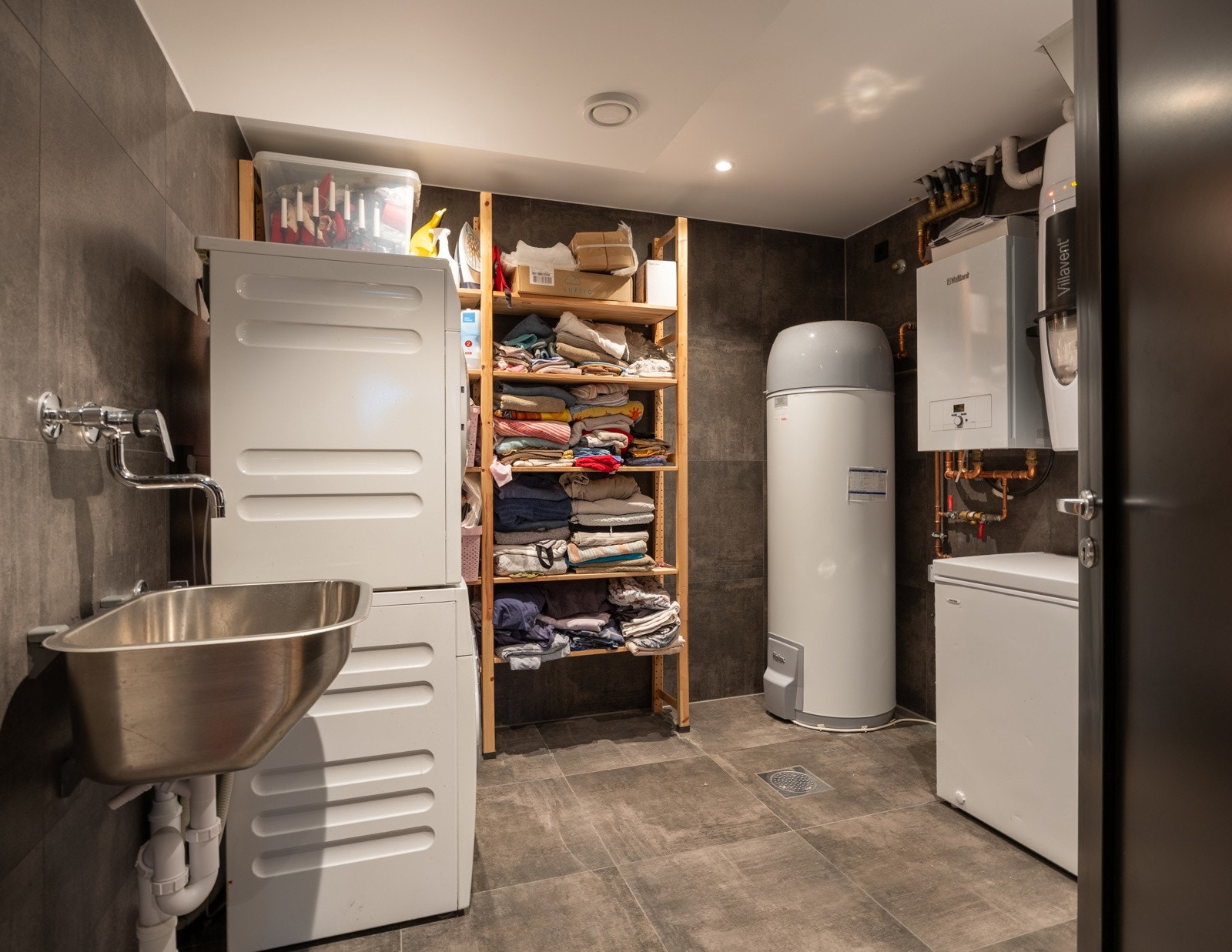 Stort vaskerom/teknisk rom med utslagsvask og opplegg for vaskemaskin og tørketromme. I teknisk rom i kjelleren er det installert en Høiax varmtvannstank med innebygd ekspansjonskar, kapasitet 300 liter, produsert i 2021. Sentralstøvsuger.