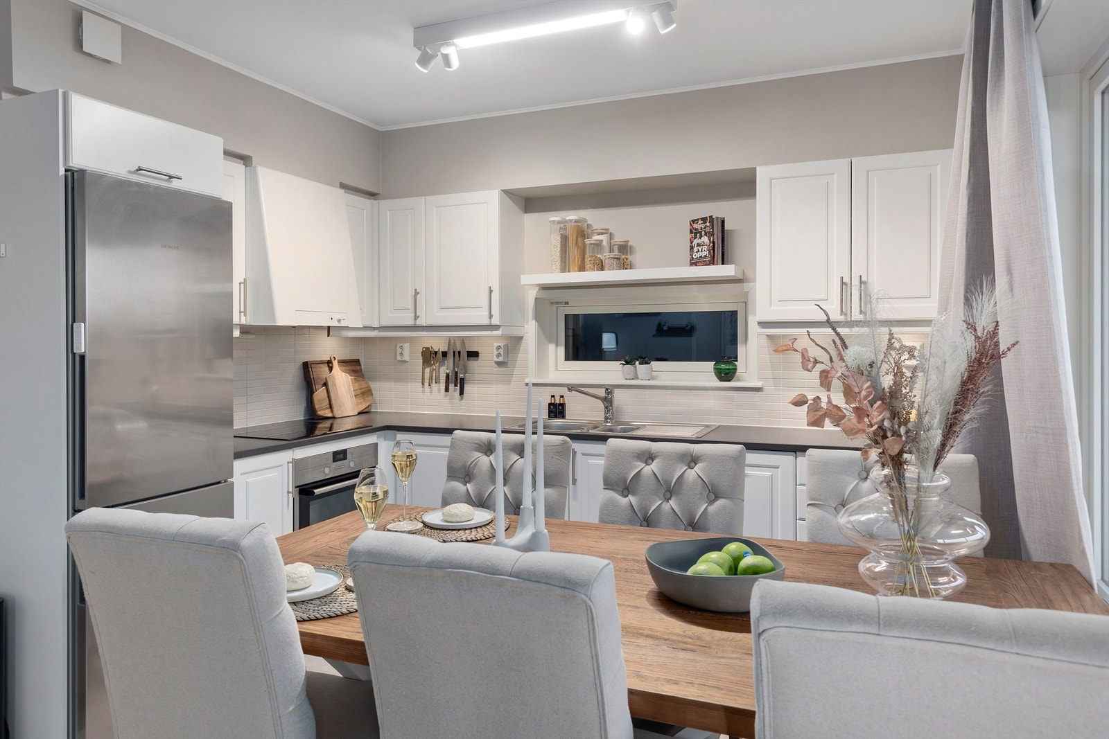 Kjøkkenet ligger naturlig tilbaketrukket fra stuen og er innredet med lyse slette flater og benkeplate i kontrast. Galleribilde