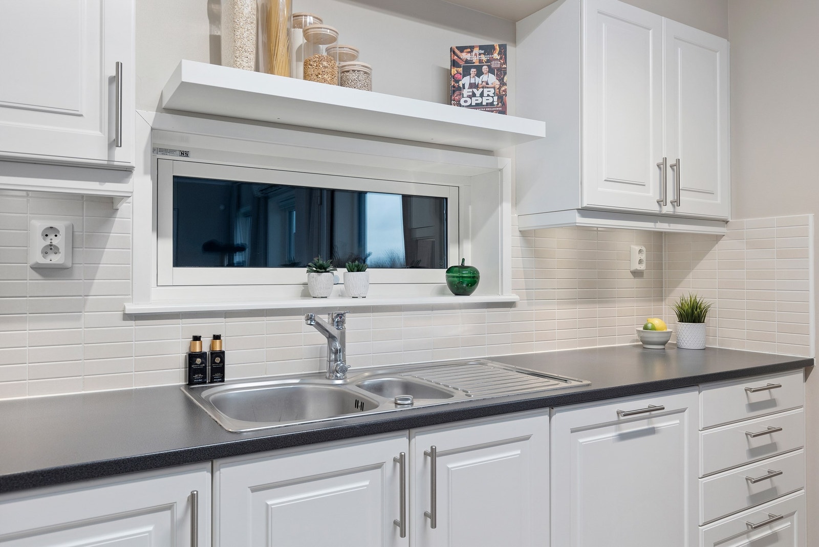 Videre er kjøkkenet innredet med integrert stekeovn, platetopp, oppvaskmaskin og kjøleskap med fryser. Galleribilde