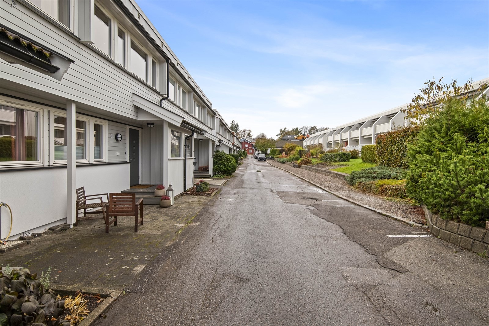 Stor felleseiet tomt for borettslaget bestående av grøntareal rundt bygningene og asfalterte internveier og parkeringsareal. Galleribilde