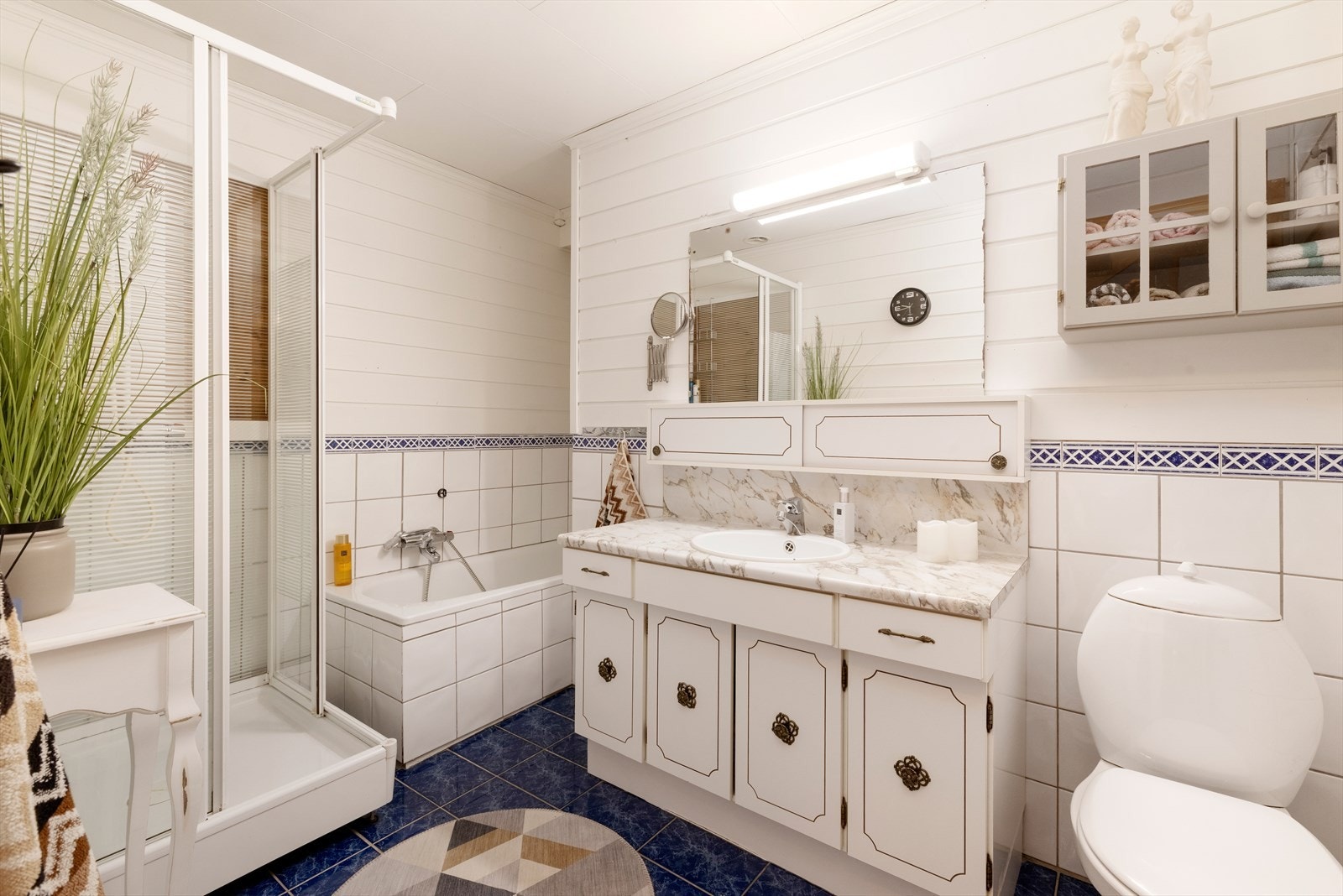 Videre er det i etasjen et romslig baderom. Baderommet er innredet med toalett, servant med oppbevaring, dusjkabinett og badekar. Galleribilde