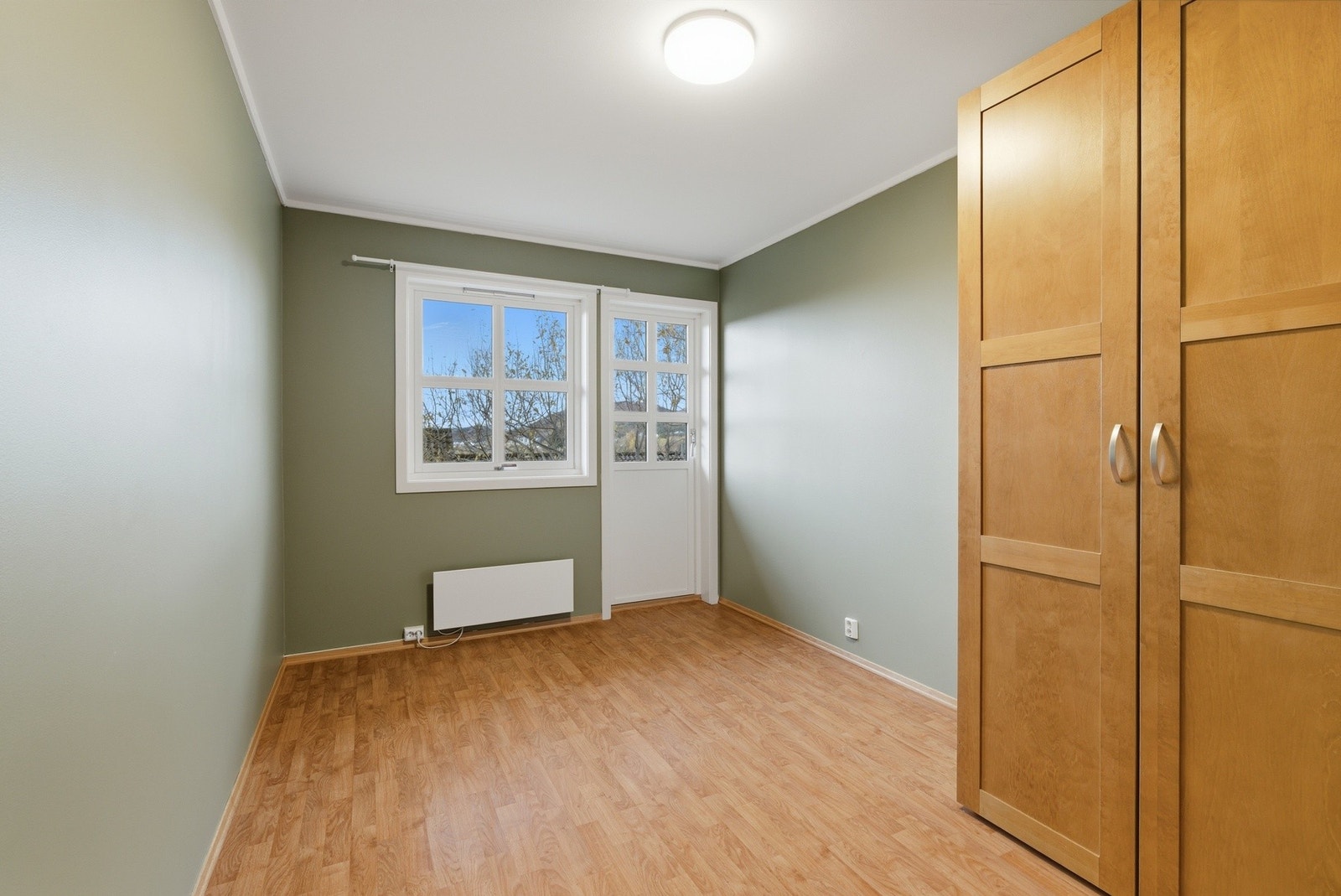 Soverom med flere garderobeskap og plass til dobbeltseng. Utgang til platting i hagen Galleribilde