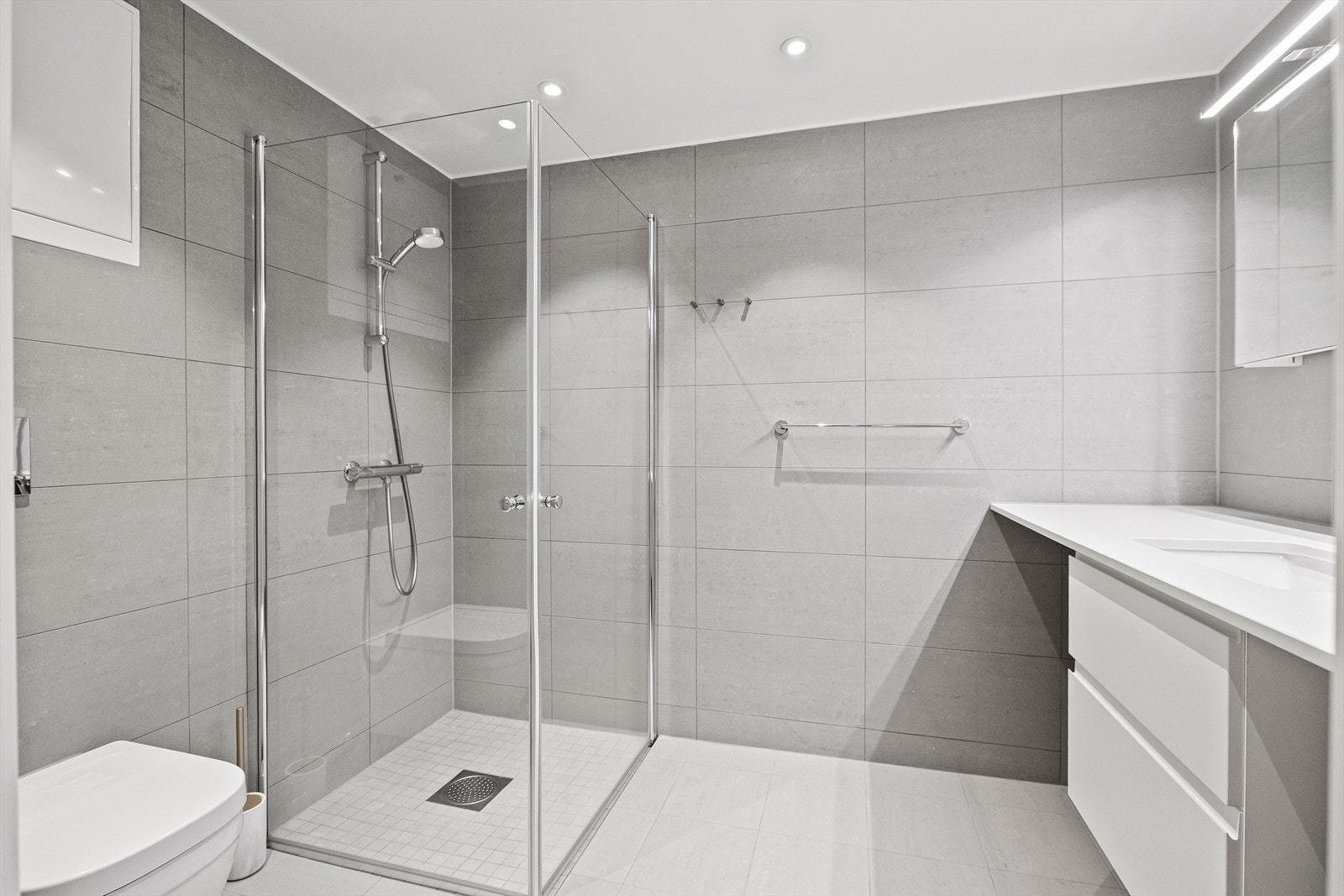 Badet er flott og delikat med dusj på vegg med innfellbare glassdører Galleribilde