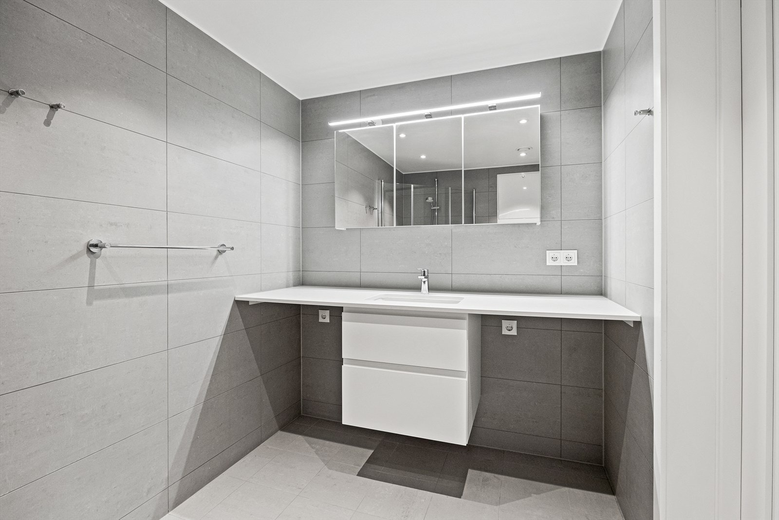 Opplegg for vaskemaskin og tørketrommel, lys over speil og rikelig med skuffeplass Galleribilde