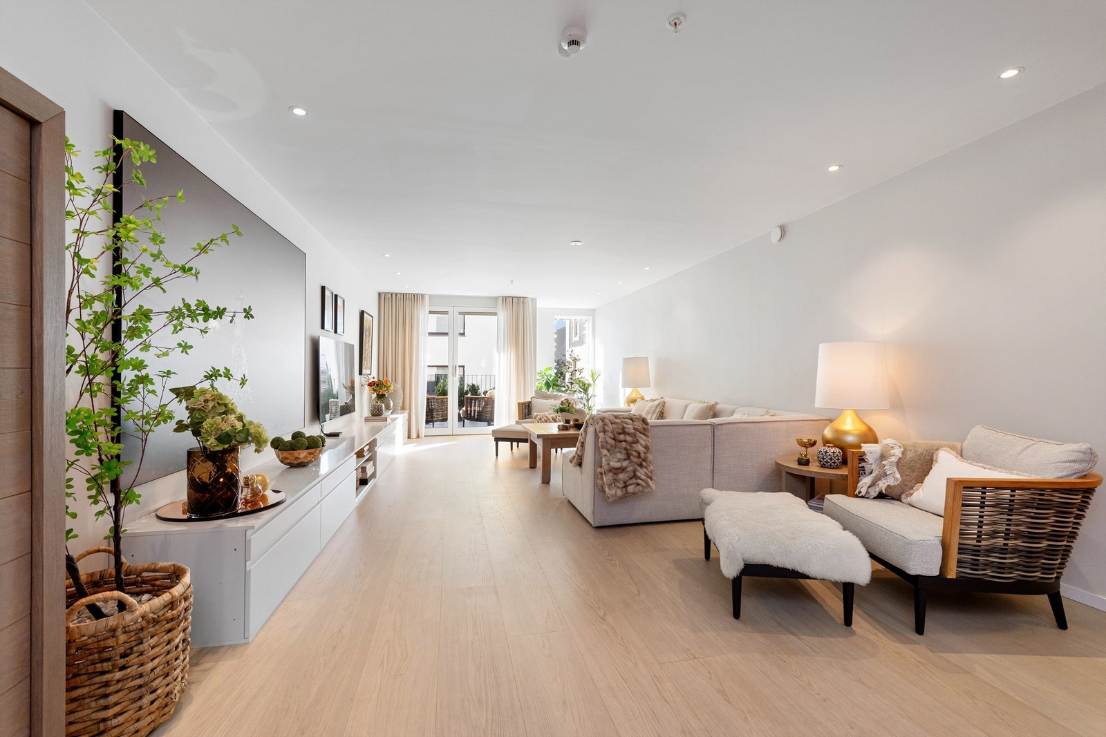 Stue og kjøkken i åpen gjennomgående løsning med lyse overflater og god romfølelse Galleribilde