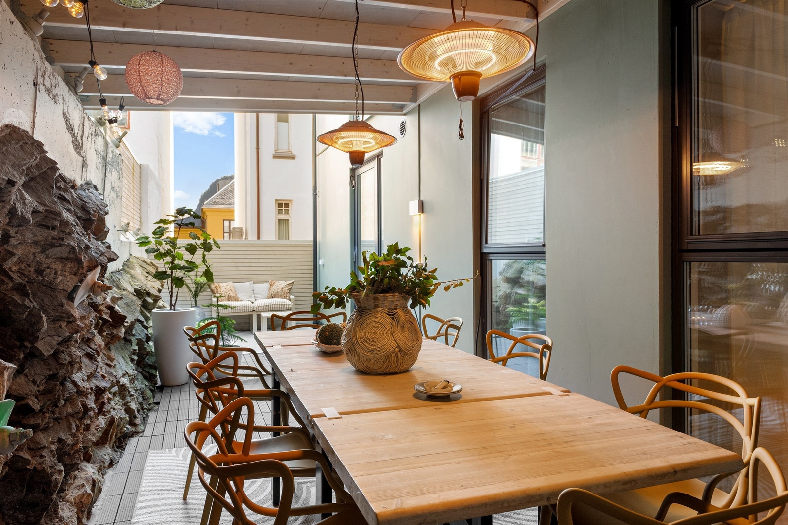 Deler av terrassen/plattingen i bakgård med utgang fra kjøkken er overbygd. Ei deilig oase med god plass til spisebord for hyggelig sosialt samvær Galleribilde