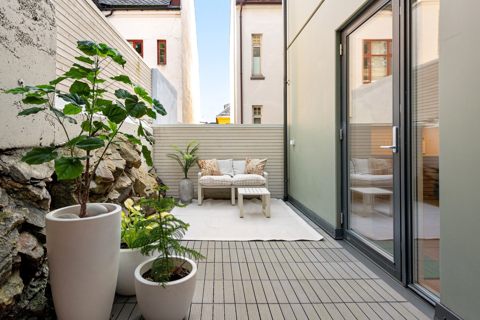 Utgang fra stue til dels terrasse og platting på terreng som er dels overbygd Galleribilde