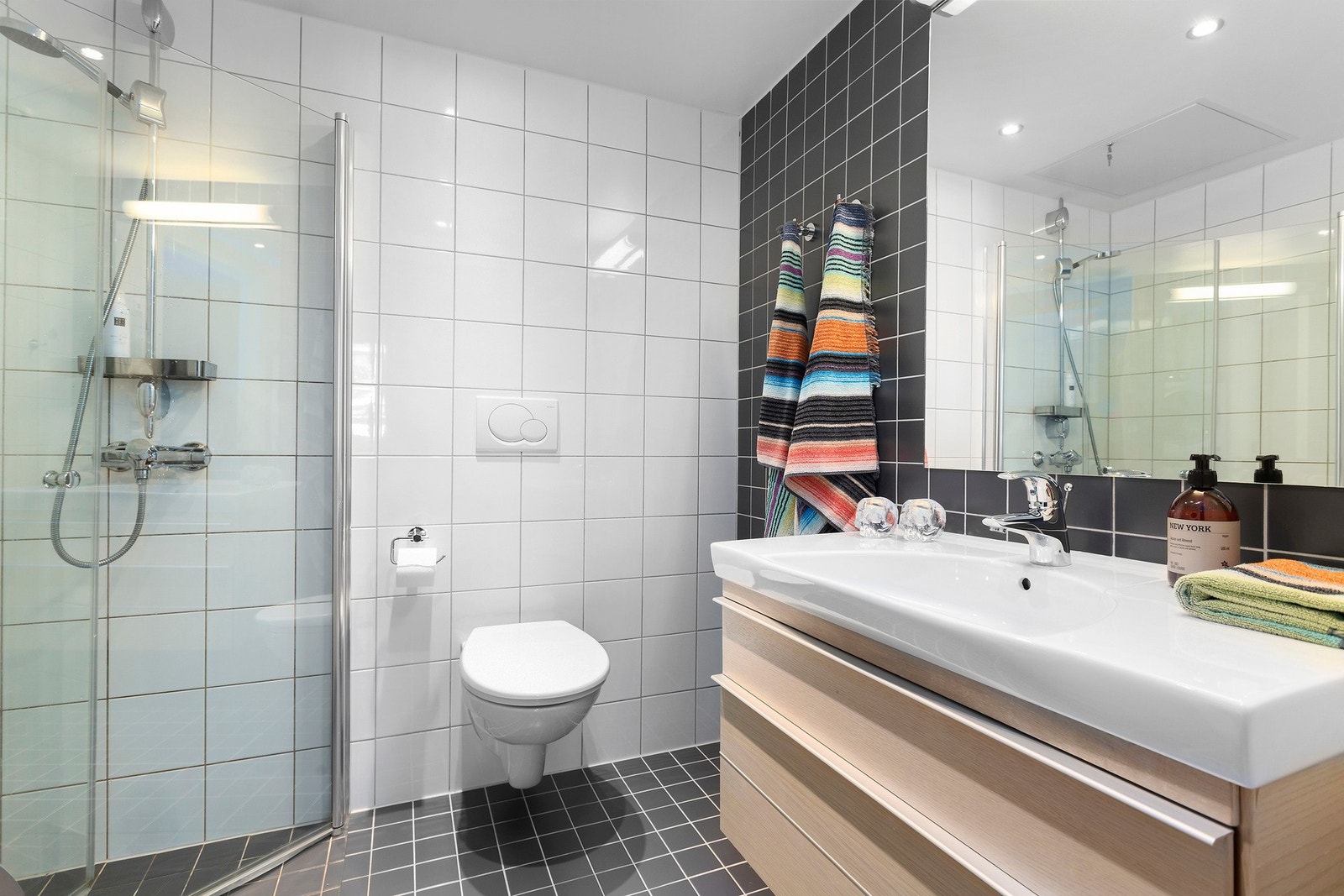 Leiligheten har et helfliset baderom med moderne innredning, varme i gulv og downlights i himling Galleribilde