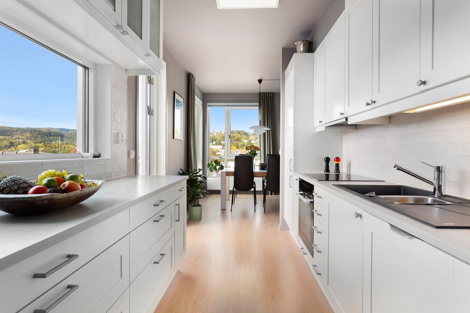 Moderne kjøkkeninnredning med hvite, profilerte fronter og laminat benkeplate Galleribilde