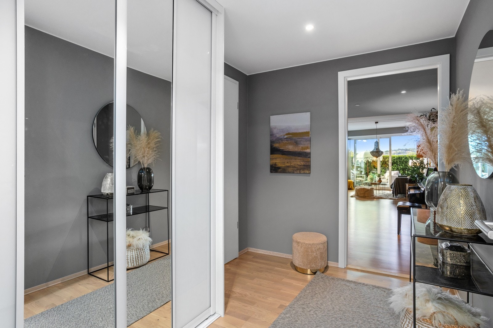 Innbydende entré med lune farger, downlightsbelysning og parkett på gulvet med underliggende varme. Galleribilde