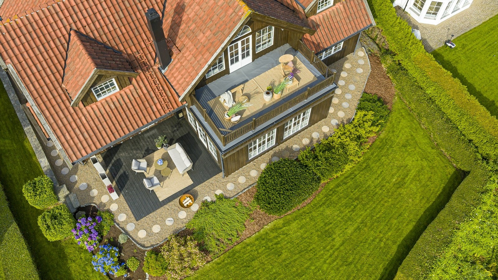 Nydelig opparbeidet tomt med hage med gressplen, beplantning, hekk, natursteinsmur, treplatting, elvestein og heller Galleribilde