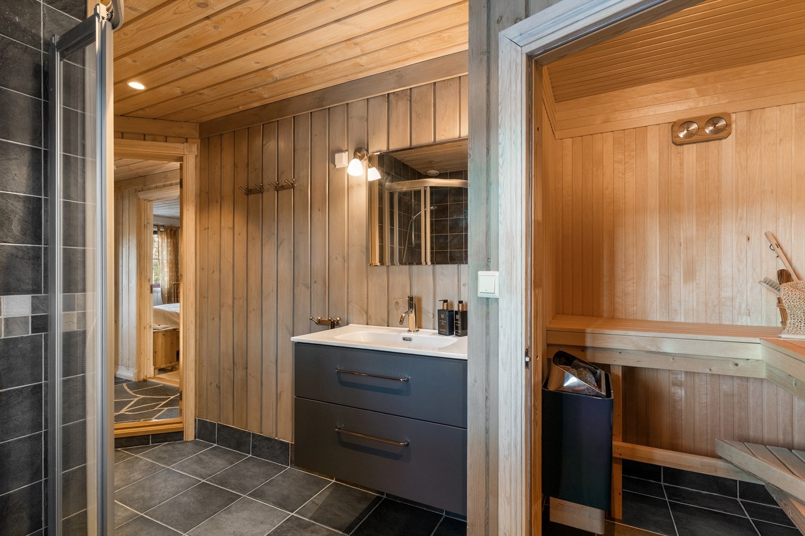 Hytta har et bad/vaskerom i første etasje. Badet har fliser på gulv med gulvvarme og trepanel på vegg. Galleribilde