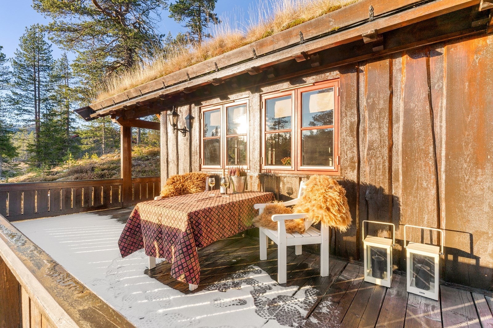 Hytta oser av tradisjon med mørkbeiset trepanel, vakre røde detaljer og torv på taket som gir den et autentisk norsk preg. Galleribilde