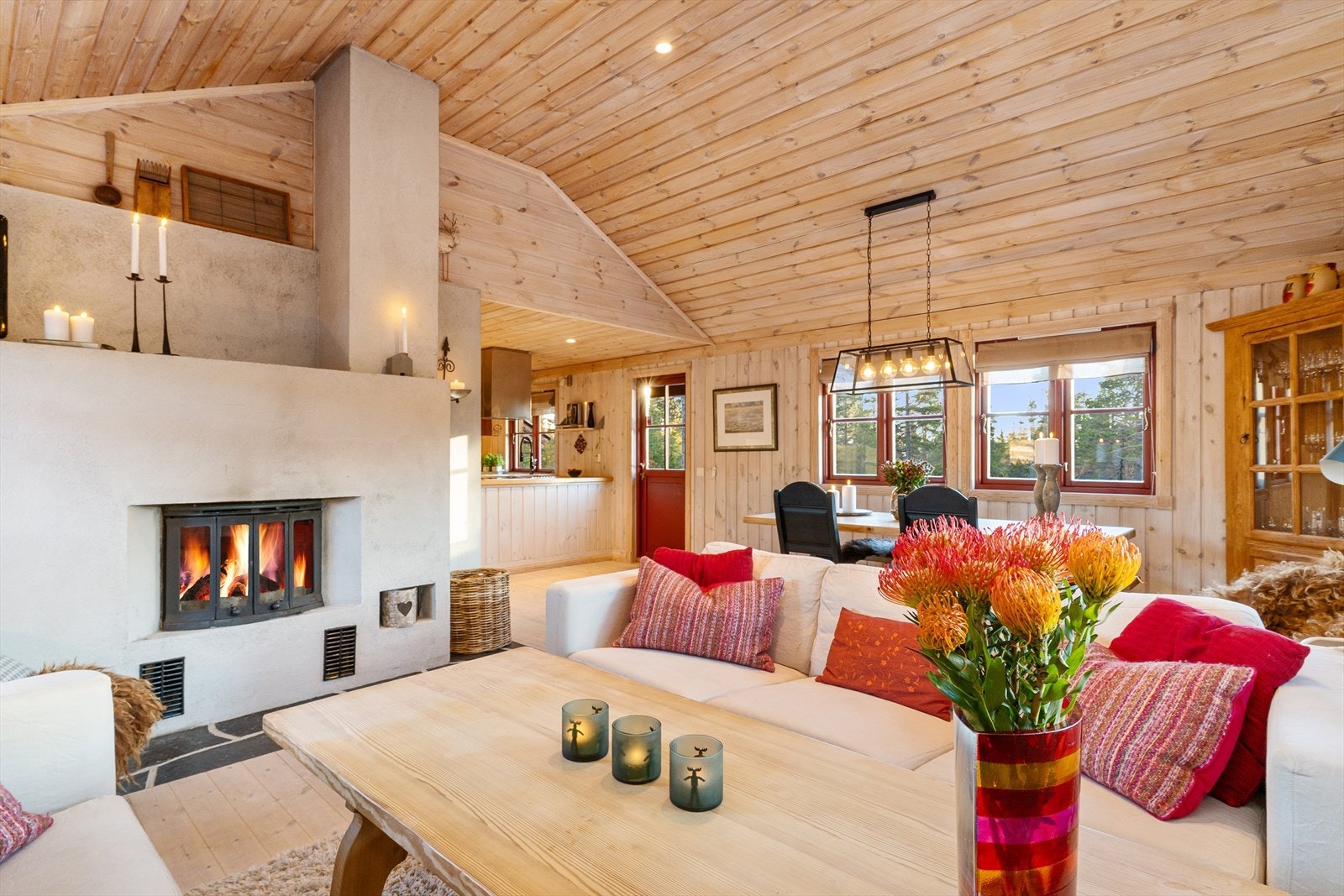 Stor og innbydende stue med gulv av furu og trepanel på vegg. Galleribilde