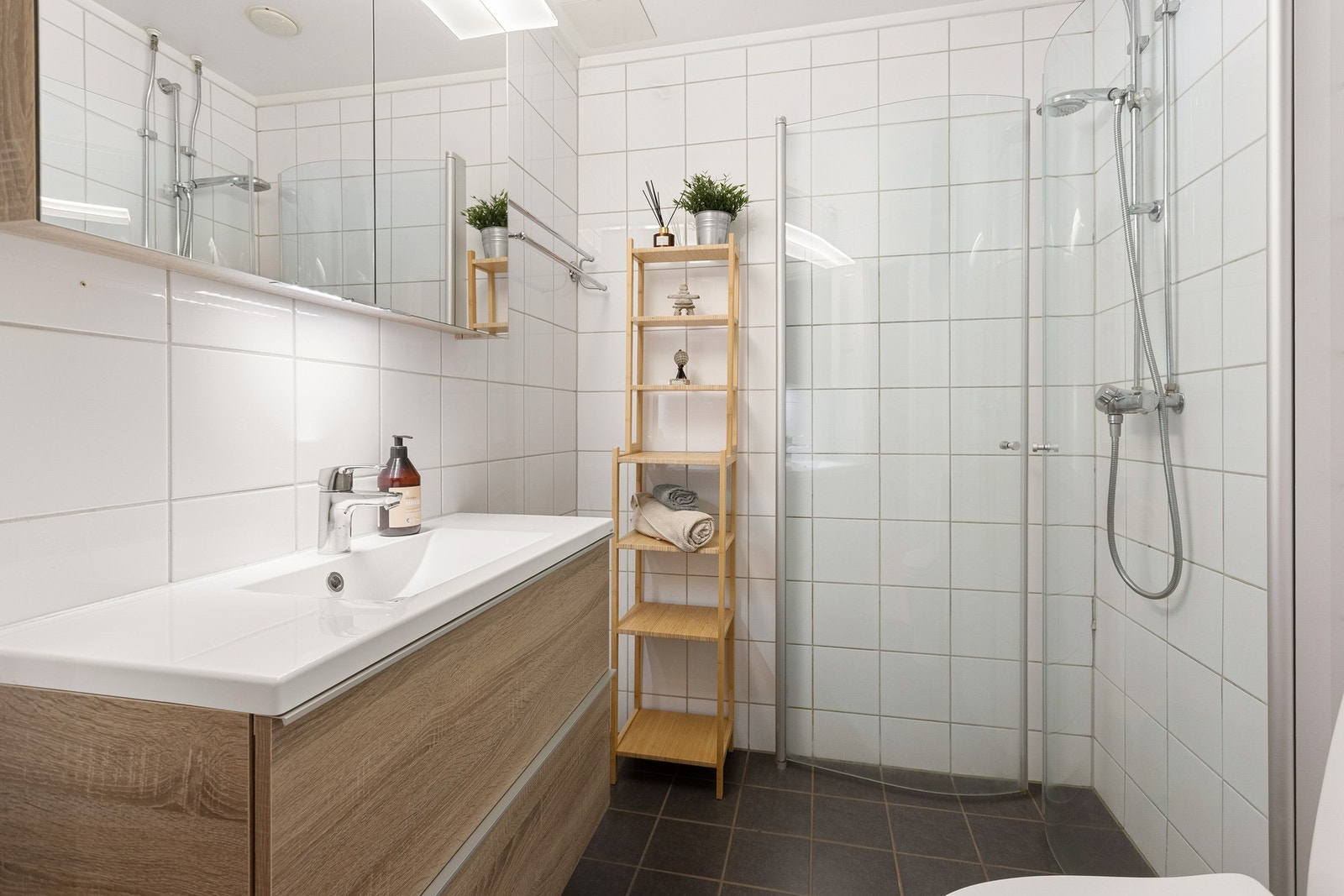 Boligens baderom er lyst og pent med varme i gulv. Det er opplegg for vaskemaskin. Galleribilde