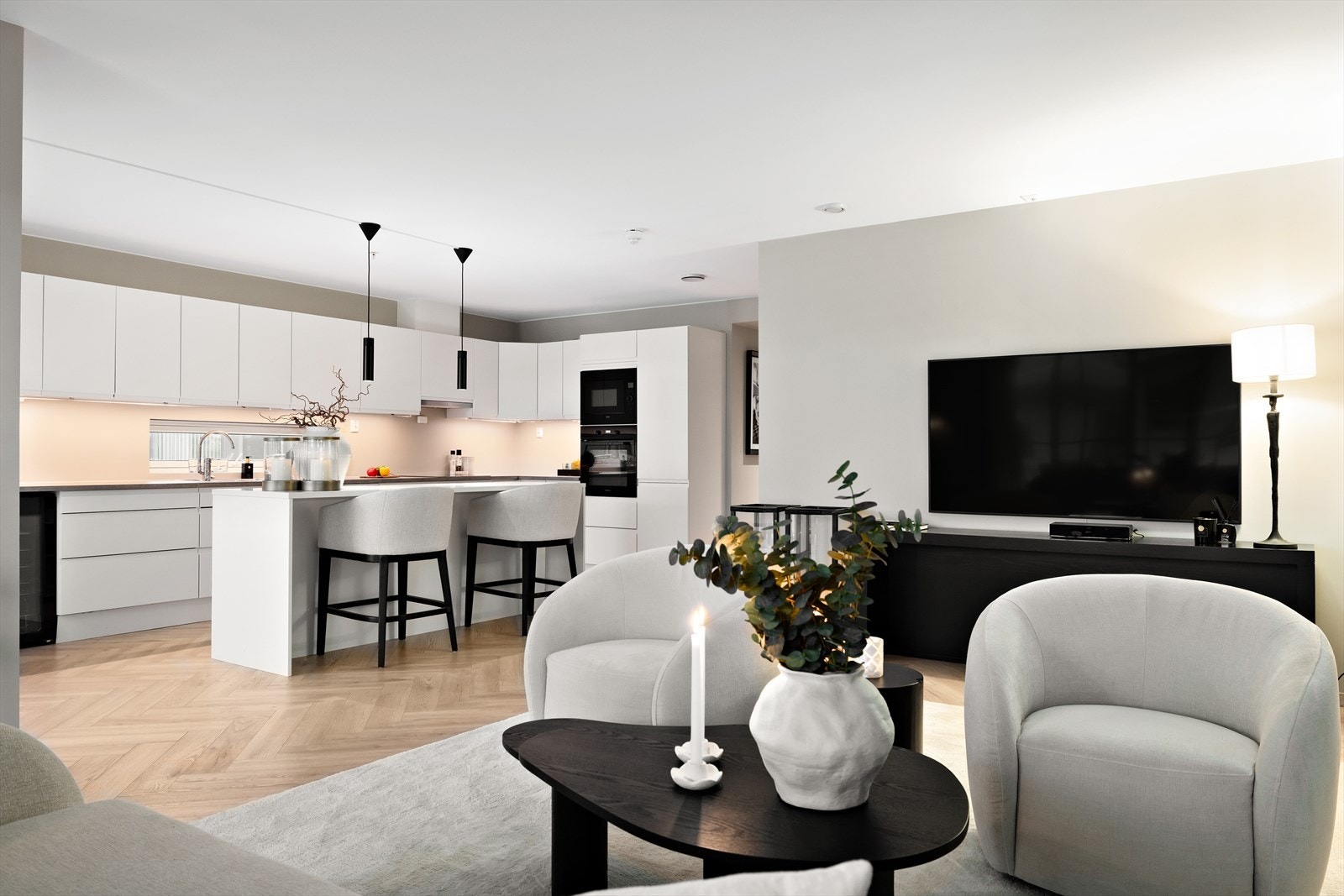 Leiligheten har en moderne, åpen stue- og kjøkkenløsning som gir en luftig og sosial romfølelse. Galleribilde