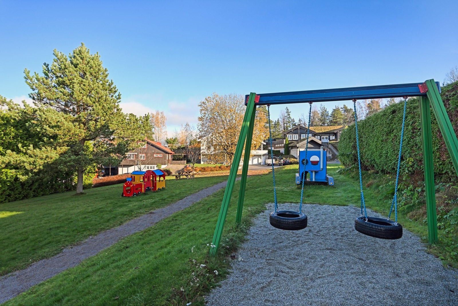 Tvers over veien, er det en koselig samlingsplass med benker, lekeapparater og husker. Galleribilde