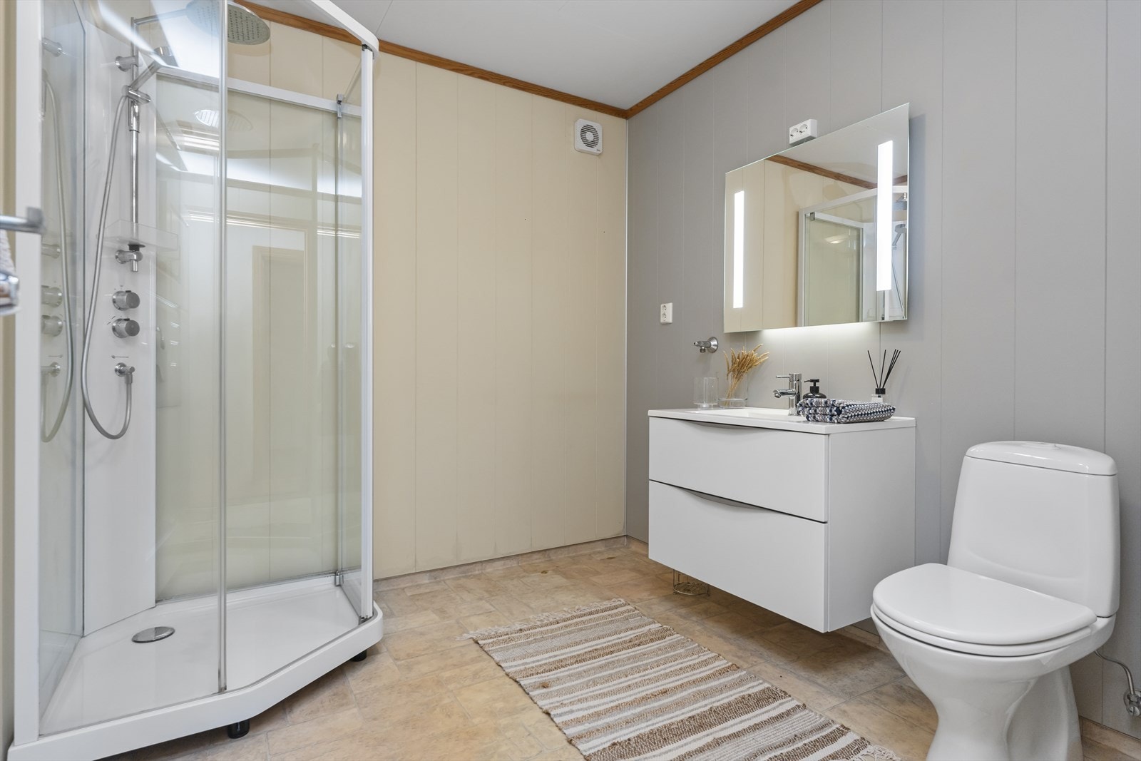 Badet har varmekabler i gulv, dusjkabinett, klosett og servant. Galleribilde