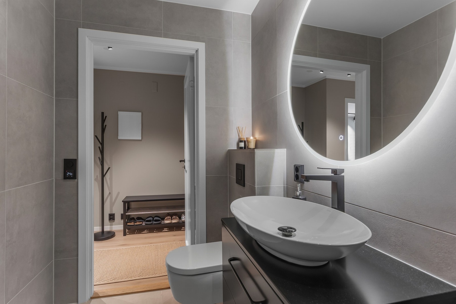 Lekker baderomsinnredning med toppmontert servant og speil med lys. Galleribilde