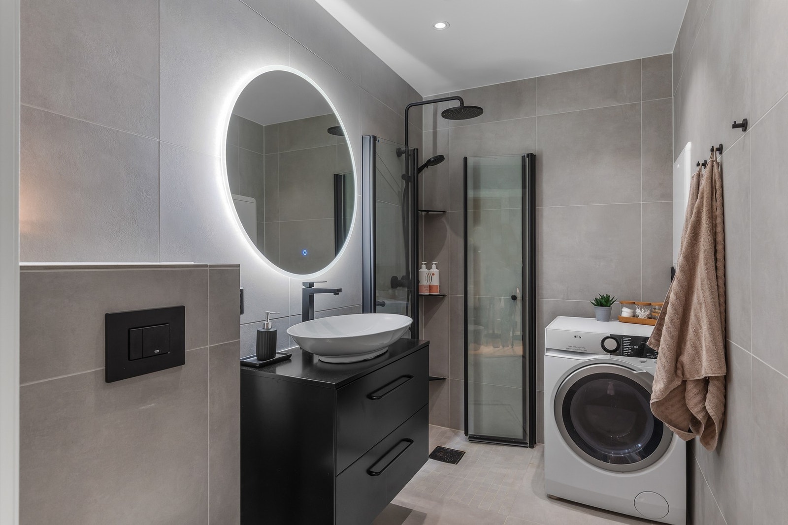 Moderne, flislagt bad med stilrene materialer og lune varmekabler i gulvet. Galleribilde