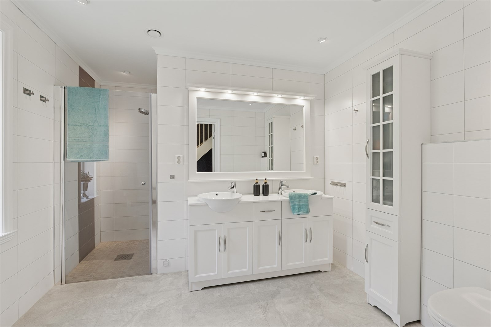 Bad i tilbygget er også av god størrelse, og består av speil med lys, dobbel servant med seksjon, samt veggmontert toalett og dusjhjørne. Galleribilde