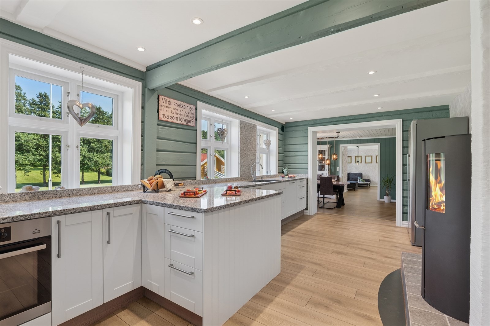 Rommet er utstyrt med downlights i taket, og en stilren peisovn bidrar til både varme og et lunt preg. Galleribilde