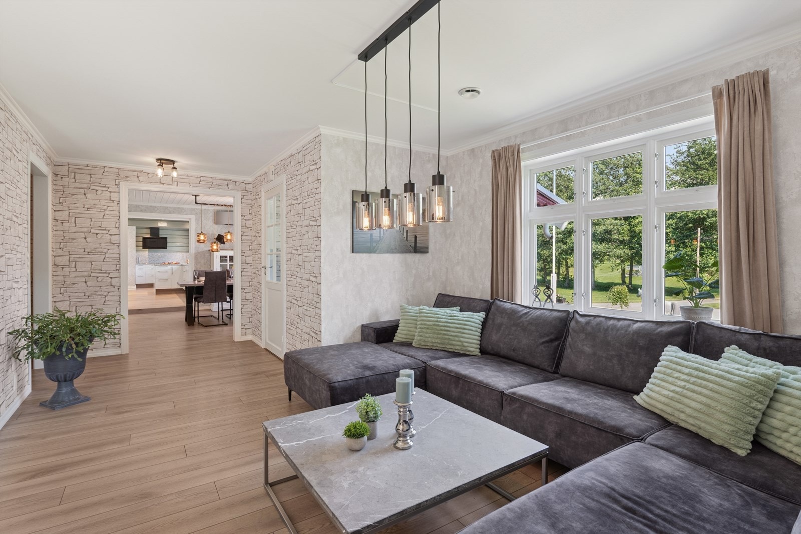 Det er en åpen og gjennomgående løsning mellom stue, spisestue og kjøkken, noe som skaper en luftig og sosial planløsning. Galleribilde