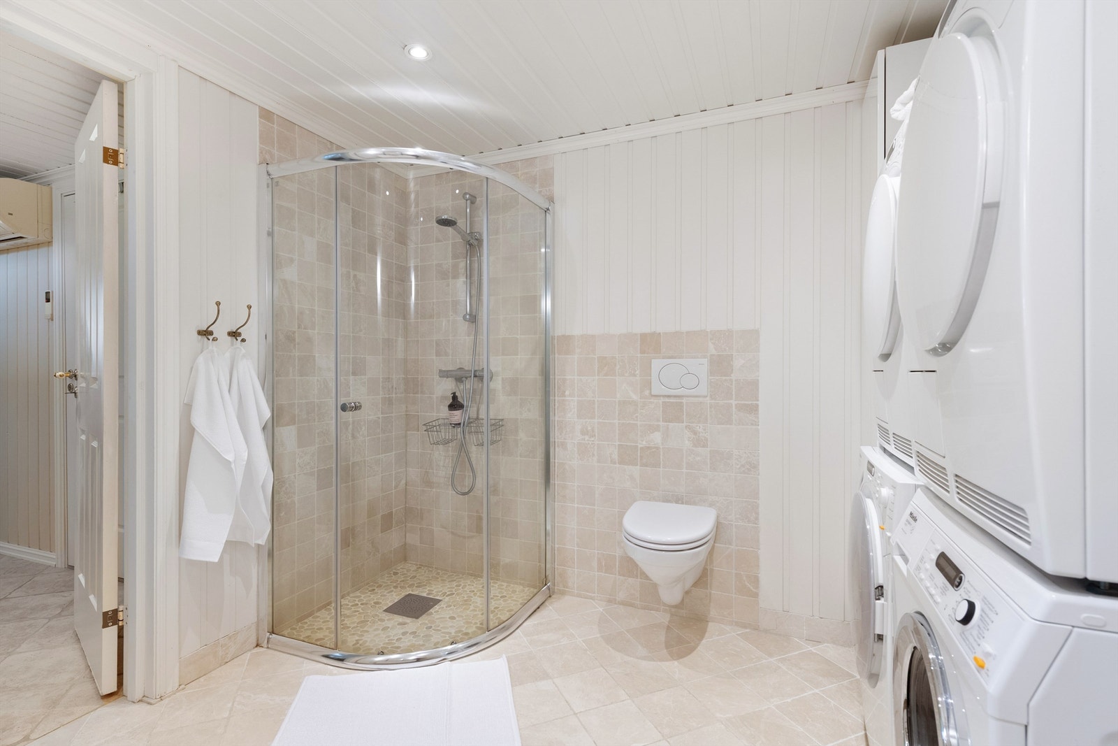 Dusjhjørne med glass skyvedør. Flislsagte vegger i dusjsone. Opplegg for vaskemaskin. Galleribilde