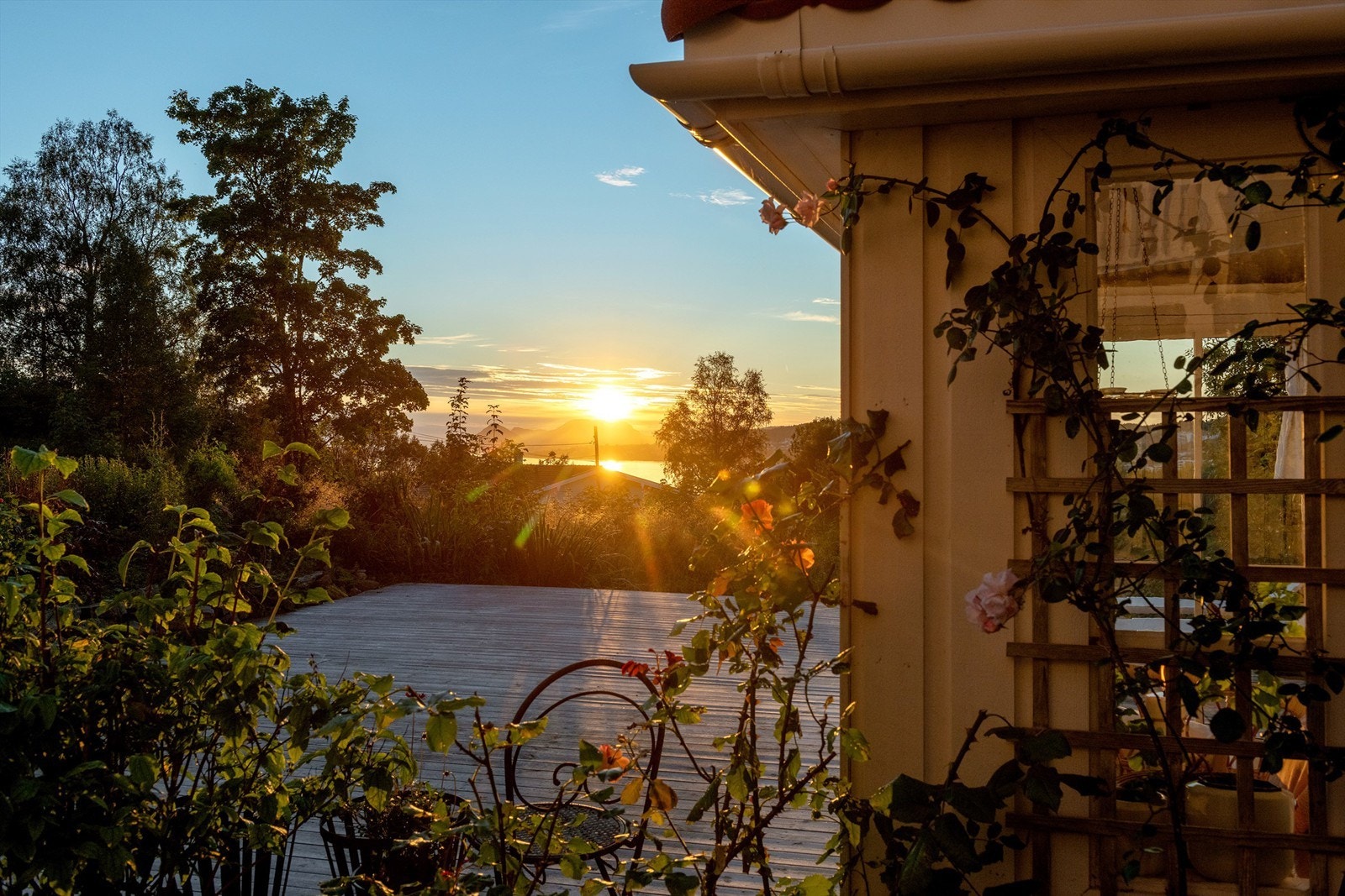 Stemningsbilde med kveldssol fra hagestuen/terrassen Galleribilde