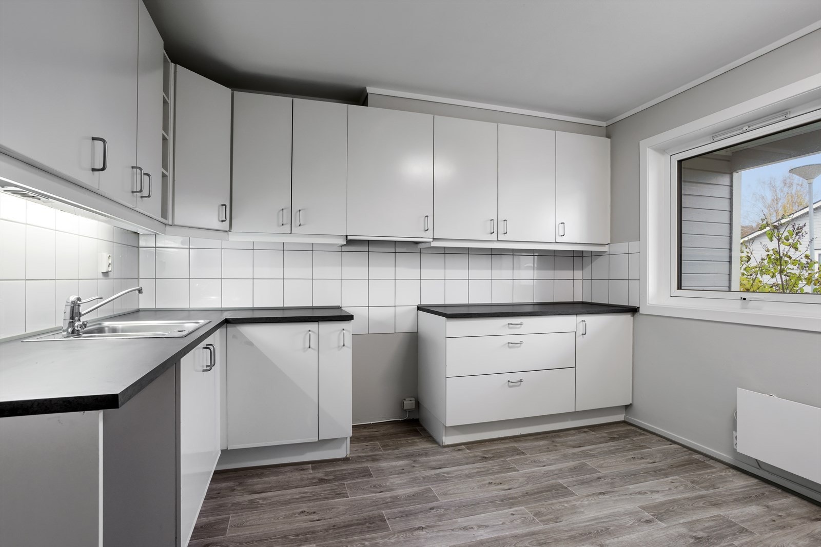 Kjøkkenet er innredet med glatte fronter og benkeplater av laminat. Galleribilde
