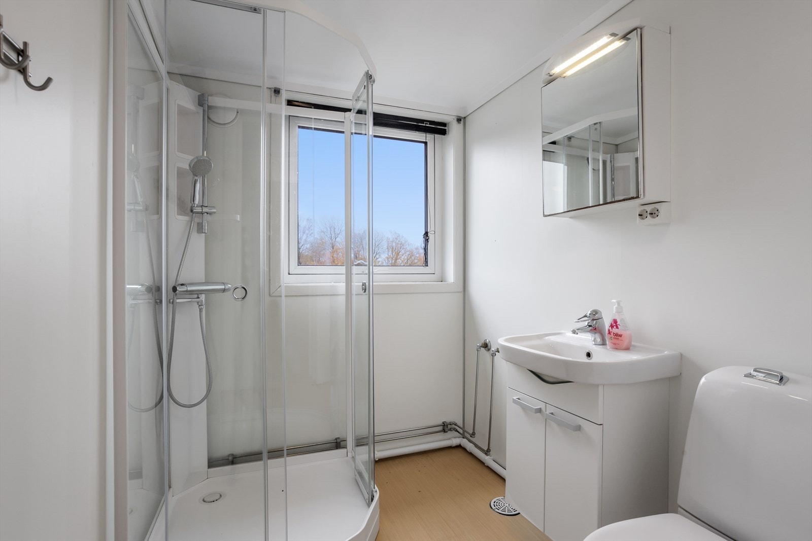 Badet i 2. etasje er innredet med gulvstående toalett, dusjkabinett og innredning med ovenpåliggende servant. Galleribilde