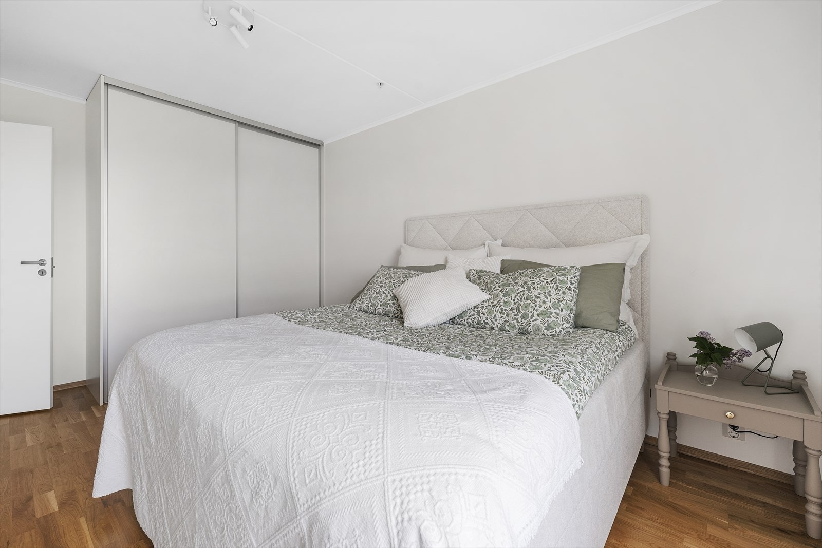 Romslig hovedsoverom med skyvedørsgarderobe med trådhyller. Galleribilde