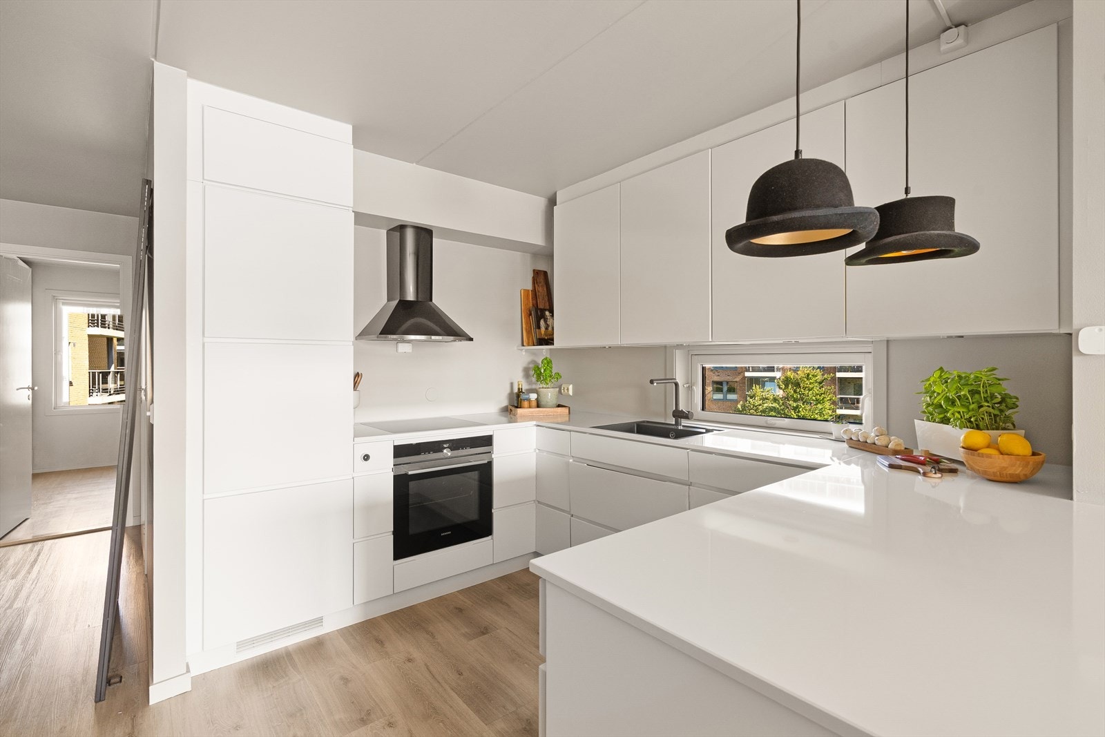 Lyst og moderne kjøkken med glatte fronter og benkeplate av stein Galleribilde