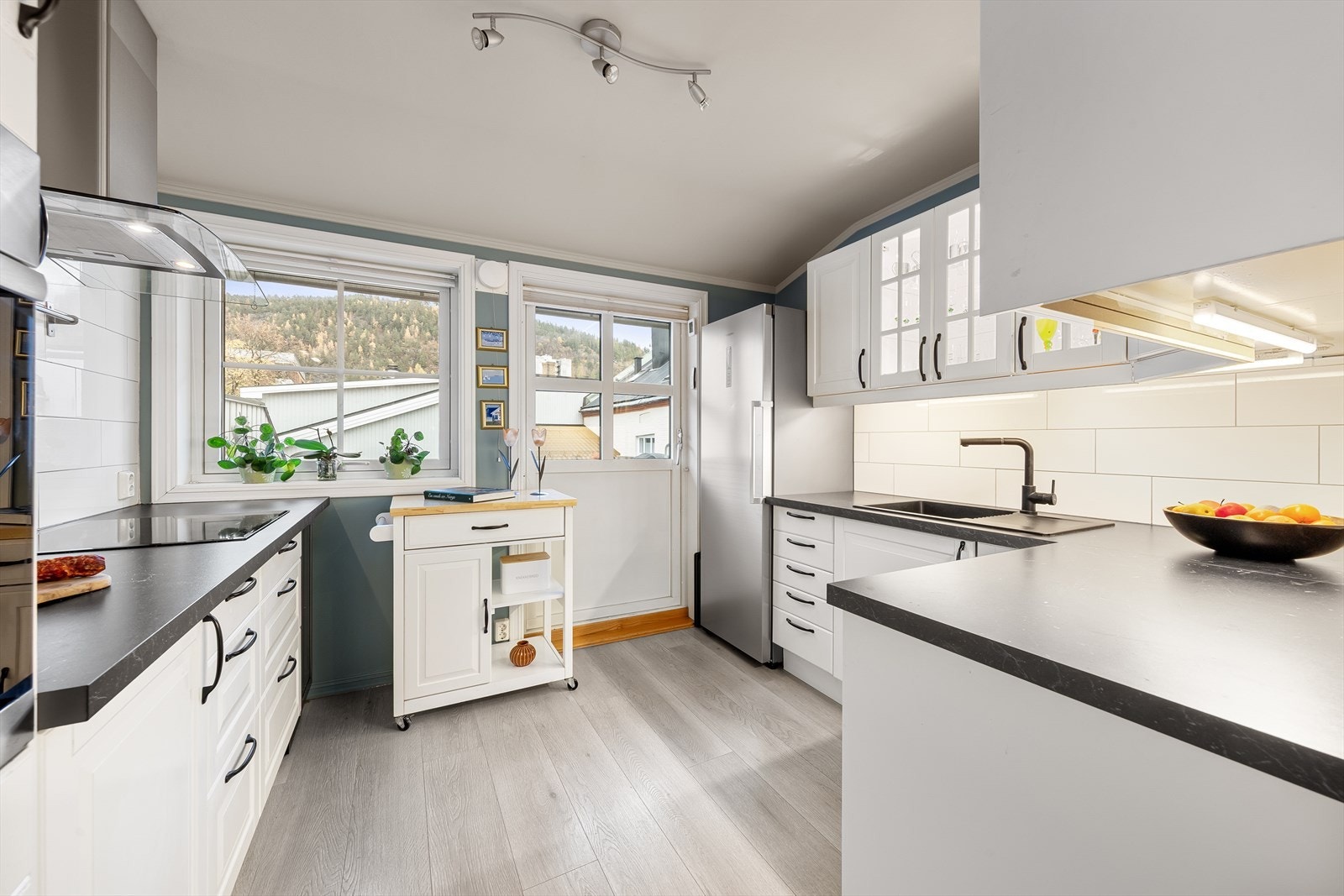 Lyst og tidløst kjøkken med alt en måtte trenge av skap-, skuff- og benkeplass. Galleribilde