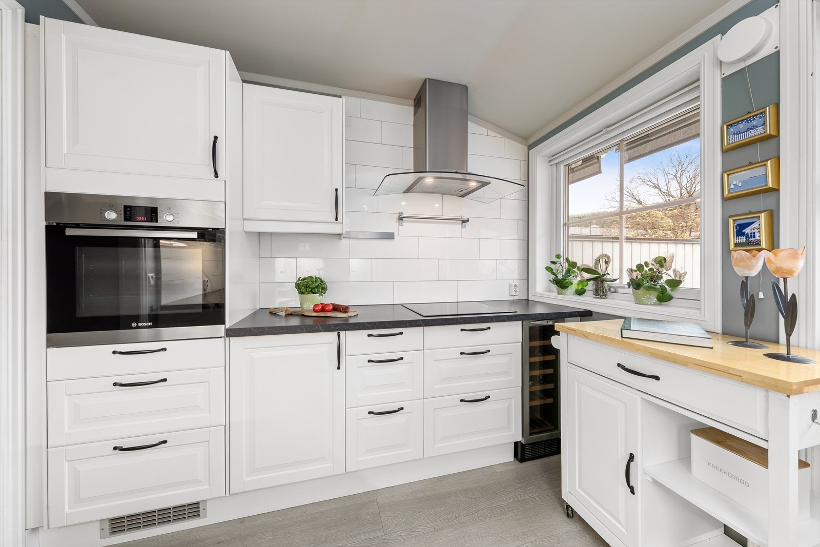 Integrerte hvitevarer som stekeovn, platetopp og vinskap. Plass for frittstående oppvaskmaskin og kjøl/frys. Galleribilde