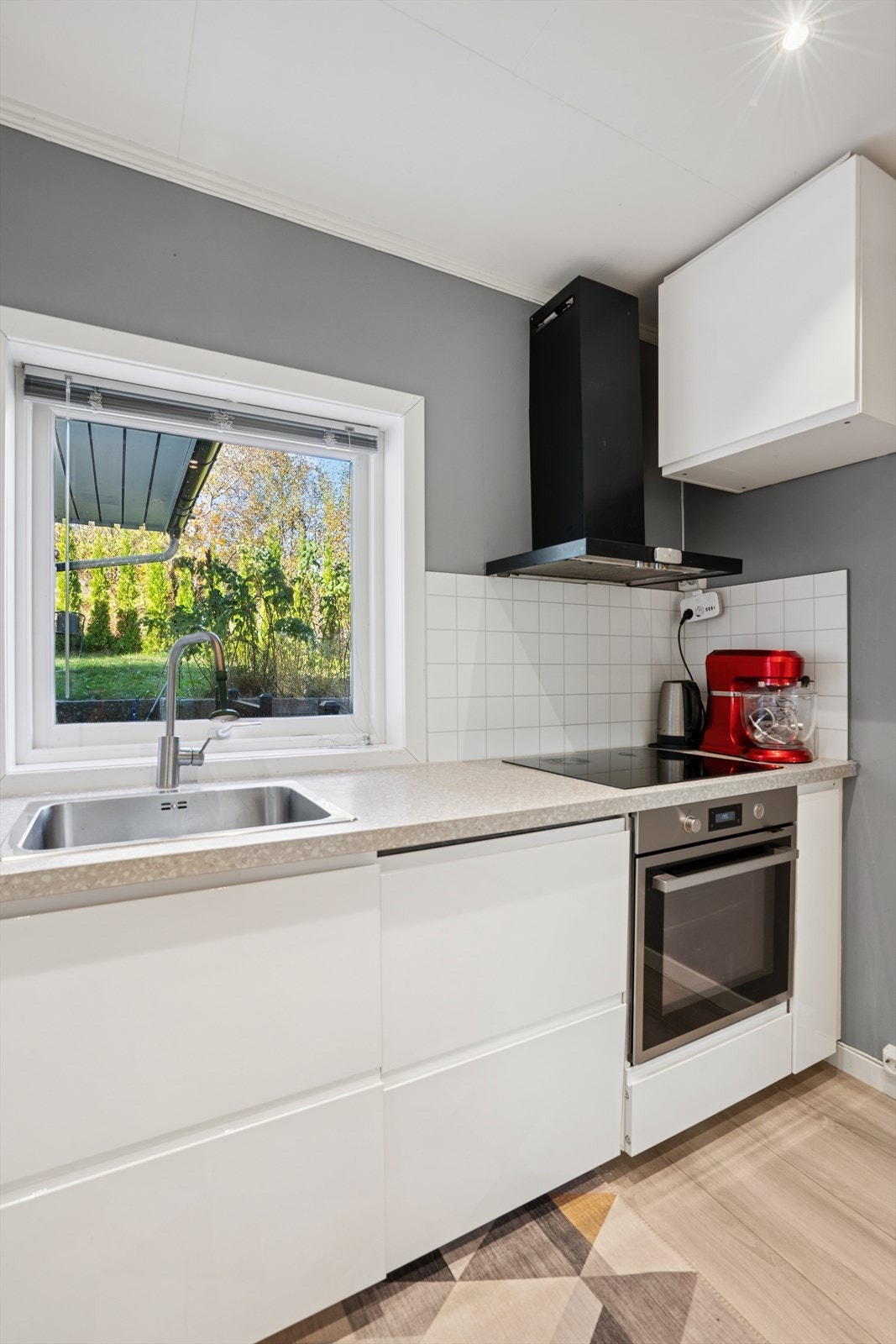 Vegg over benkeplaten har kjøkkenplater, praktisk ved matlaging. Galleribilde