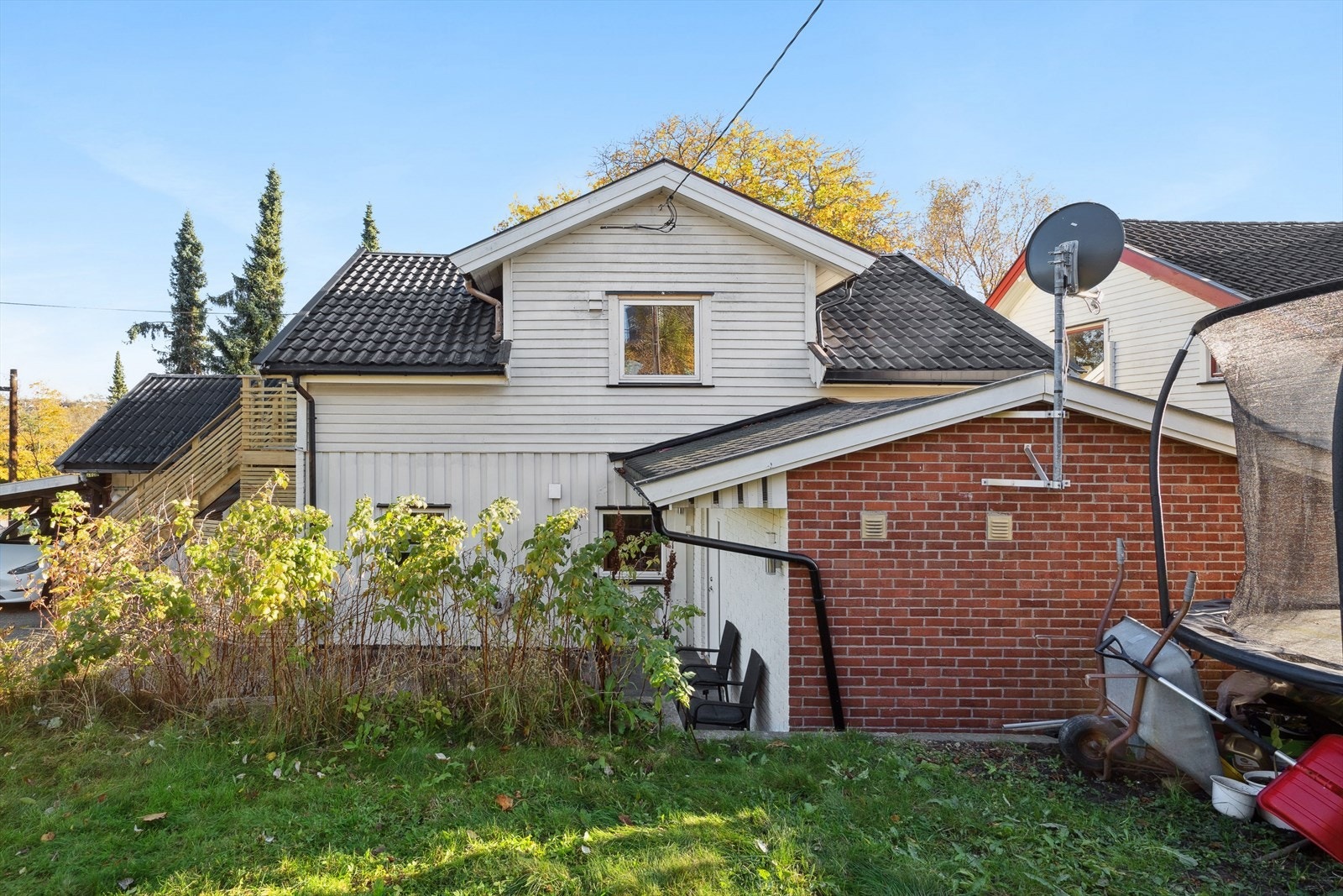 Tomten er skrånende opparbeidet med bl.a. støttemur, plen, busker, samt hekkbeplantning. Galleribilde