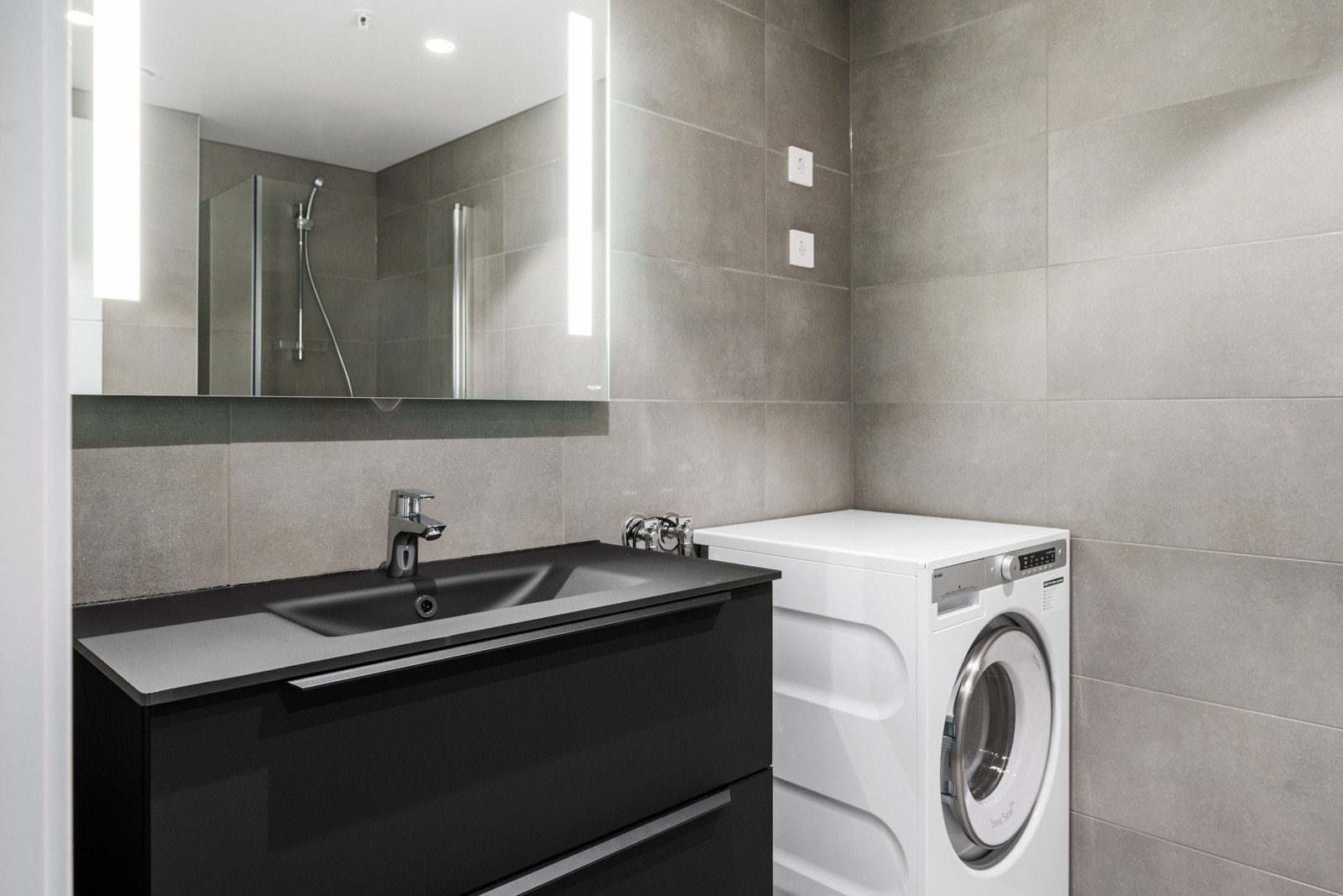 Baderomsinnredningen har nedfelt servant og speil med belysning. Galleribilde