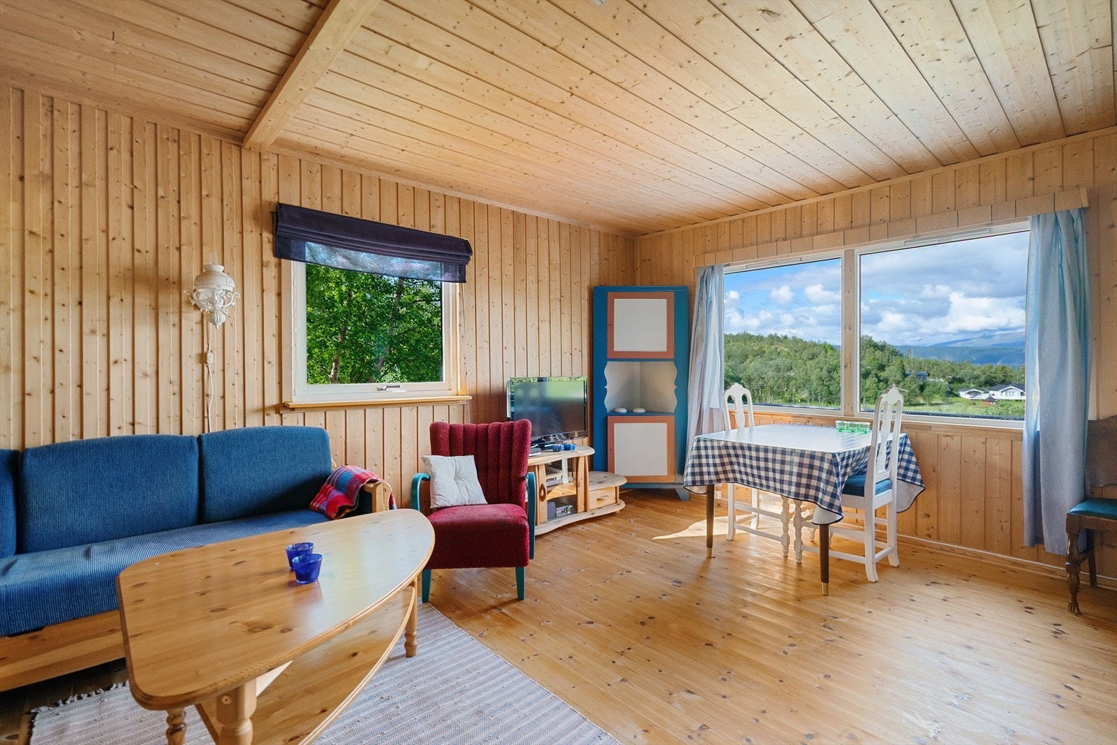 Lyst og trivelig oppholdsrom med store vindusflater som slipper inn rikelig med dagslys og gir flott utsikt mot fjorden og omgivelsene Galleribilde