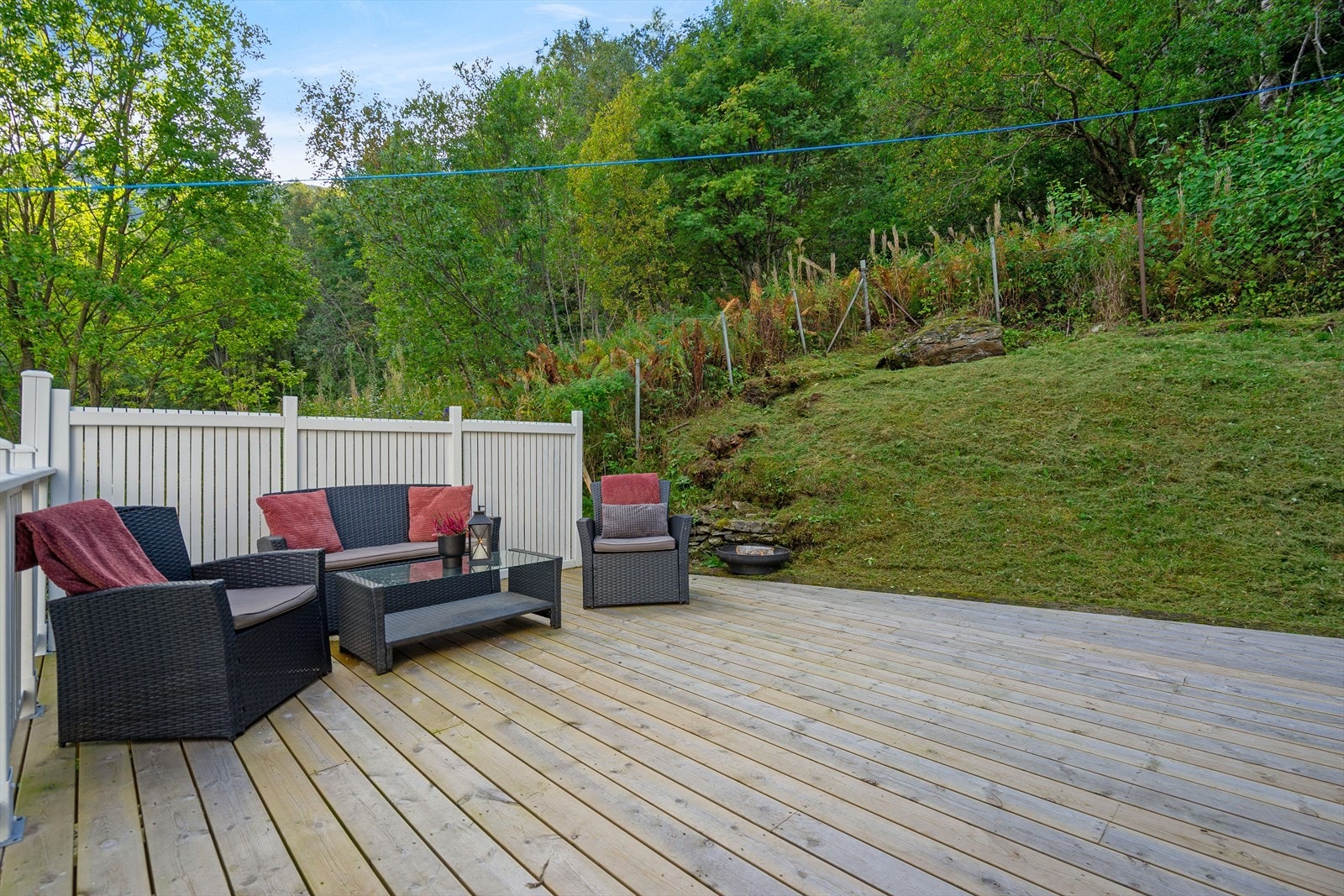 Terrassen ved inngangspartiet ligger lunt til med skjerming mot skogen bak Galleribilde